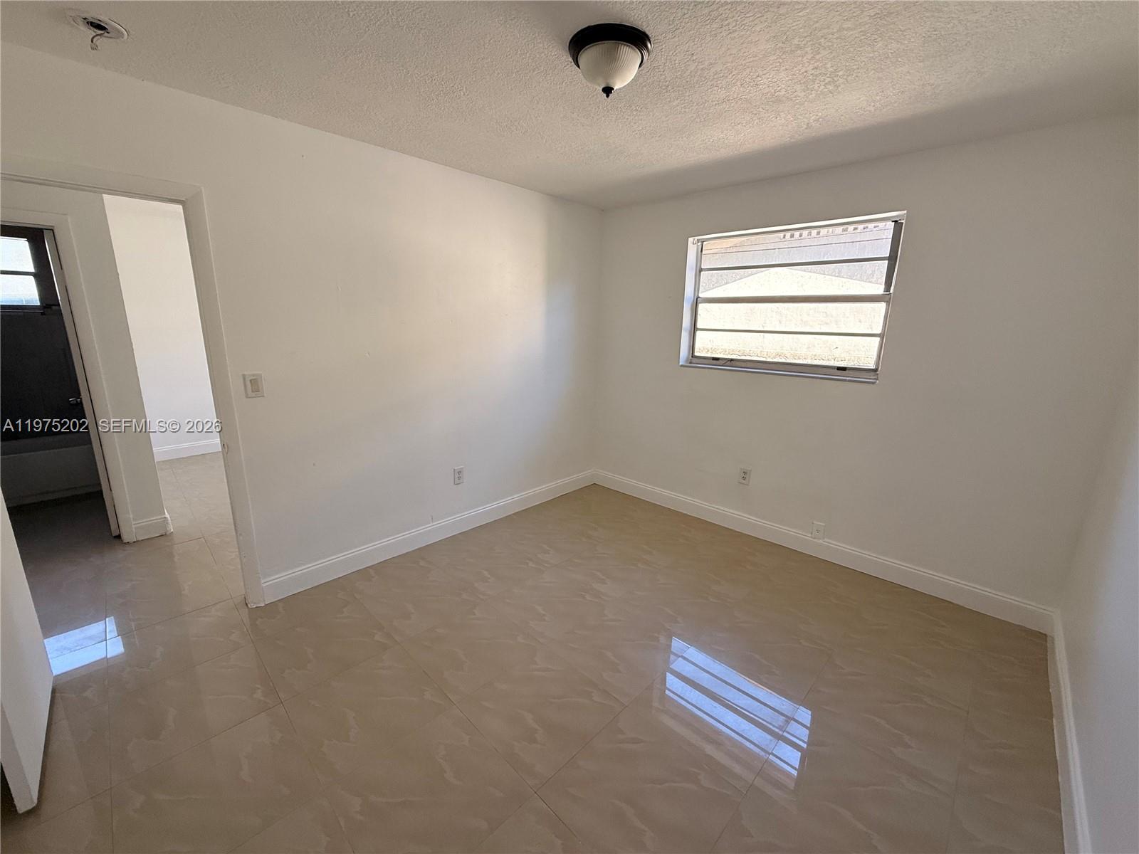 313 Northeast 57th Street, Unit 313 Miami, FL 33137 - Photo 8 of 13 an empty room with windows