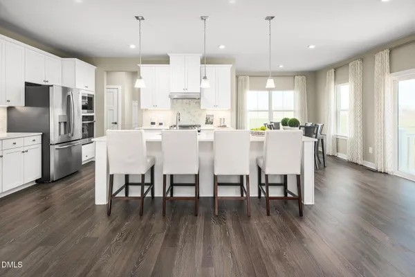 a large kitchen with cabinets table and chairs