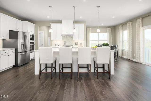 a large kitchen with cabinets table and chairs
