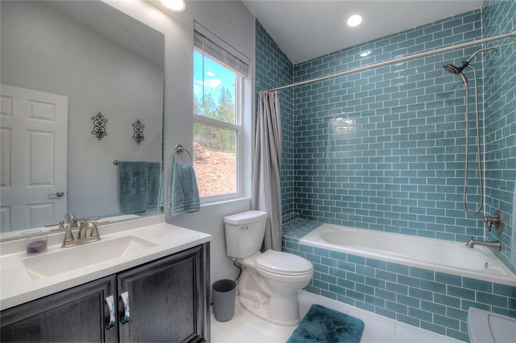 217 G Road Silverthorne, CO 80498 - Photo 13 of 24 a bathroom with a sink a toilet a mirror a vanity and bathtub