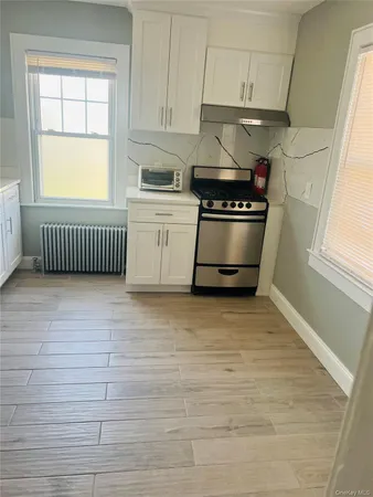a kitchen with granite countertop white cabinets and window
