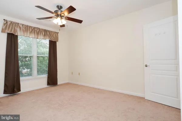 a view of a livingroom with a ceiling fan and window