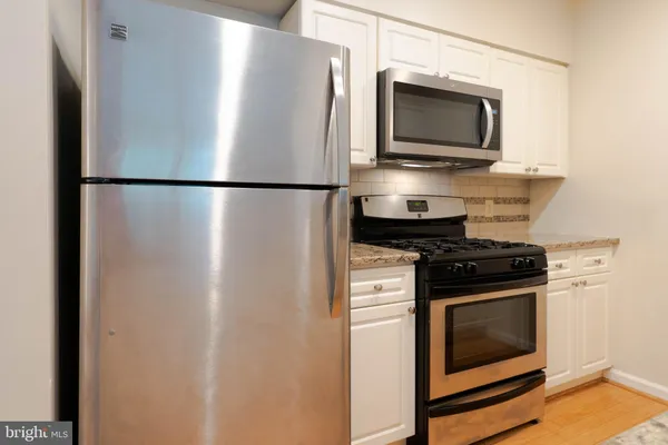a metallic refrigerator freezer sitting in a kitchen