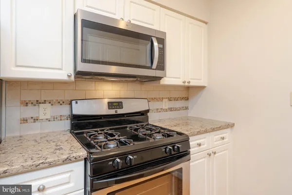 a stove top oven sitting inside of a kitchen