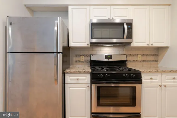 a kitchen with stainless steel appliances white cabinets and a stove