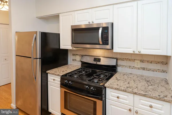 a kitchen with stainless steel appliances granite countertop a stove and a refrigerator