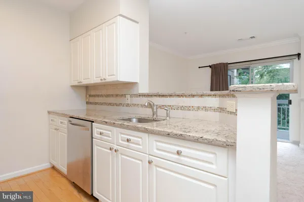 a kitchen with granite countertop white cabinets and white appliances
