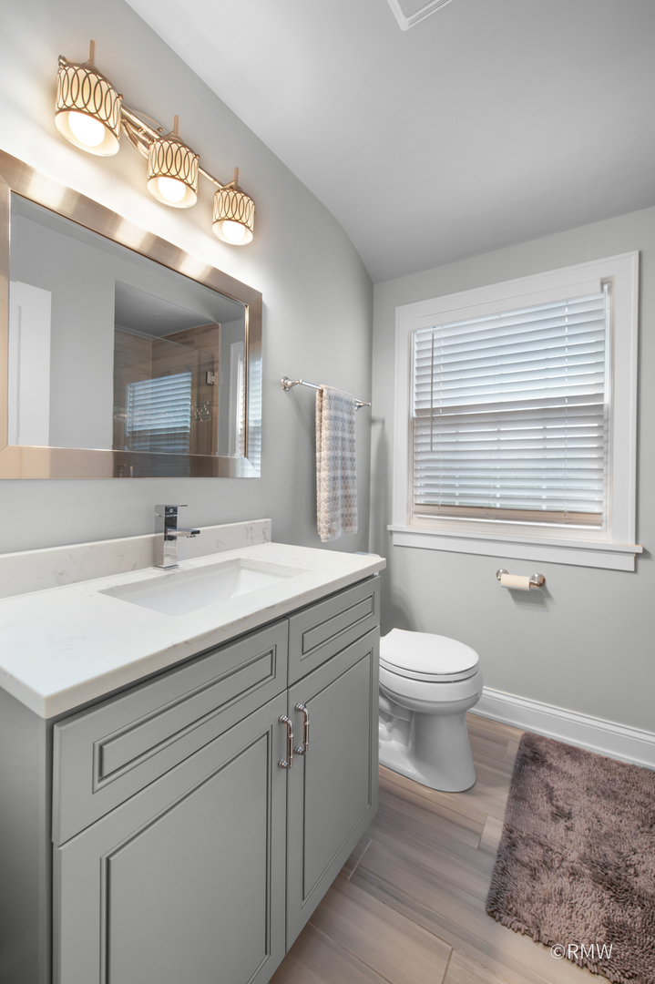 430 North Maple Street Itasca, IL 60143 - Photo 27 of 43 a bathroom with a toilet a sink a vanity and mirror