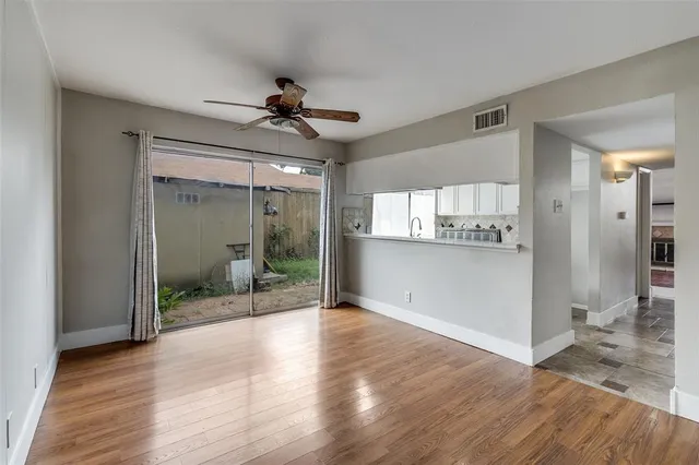 a view of a hallway with wooden floor and a living room