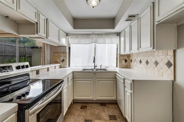 a kitchen with a sink stove and cabinets