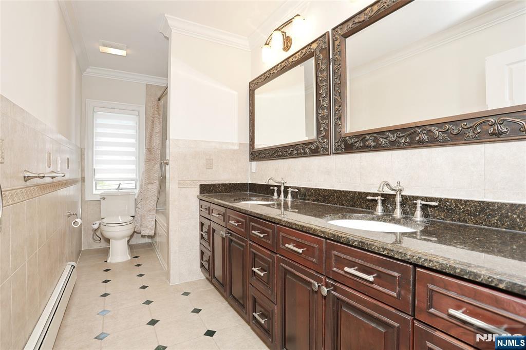 65 Ross Avenue Demarest, NJ 07627 - Photo 36 of 48 a spacious bathroom with a granite countertop sink a toilet and a mirror
