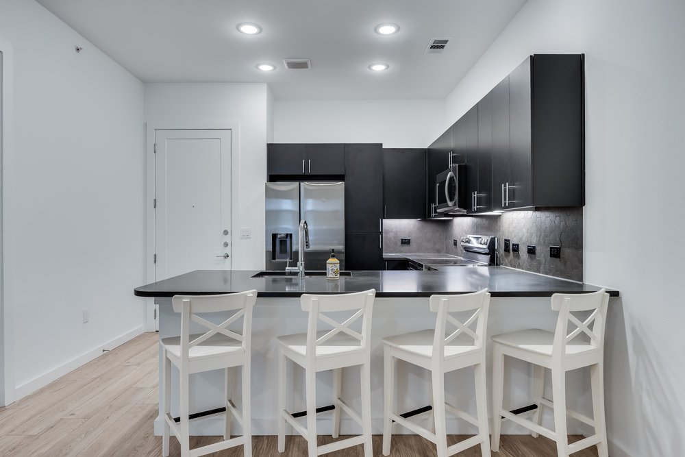 4801 Springdale Road, Unit 2107 Austin, TX 78723 - Photo 9 of 26 a kitchen with kitchen island cabinets and chairs in it