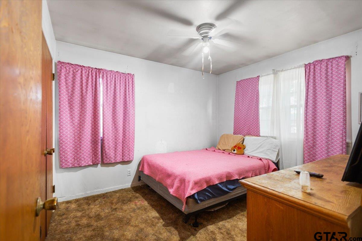 3211 Shady Trail Drive Tyler, TX 75702 - Photo 14 of 30 a bedroom with a bed and a chandelier