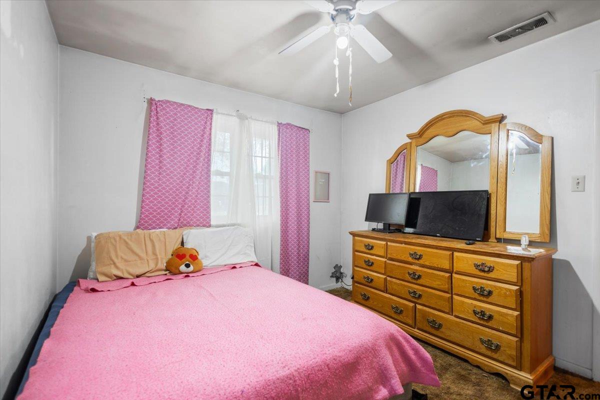 3211 Shady Trail Drive Tyler, TX 75702 - Photo 15 of 30 a bedroom with a bed and a flat screen tv