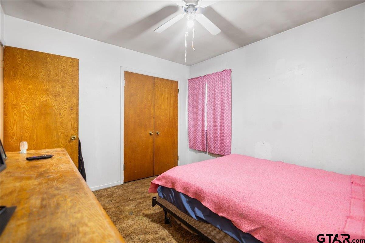 3211 Shady Trail Drive Tyler, TX 75702 - Photo 16 of 30 a bedroom with a bed and a chandelier