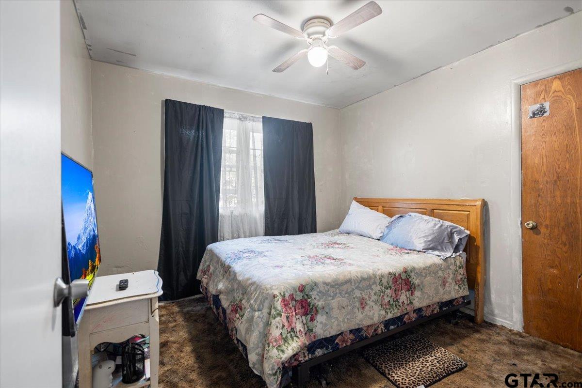 3211 Shady Trail Drive Tyler, TX 75702 - Photo 17 of 30 a bedroom with a bed and a chandelier