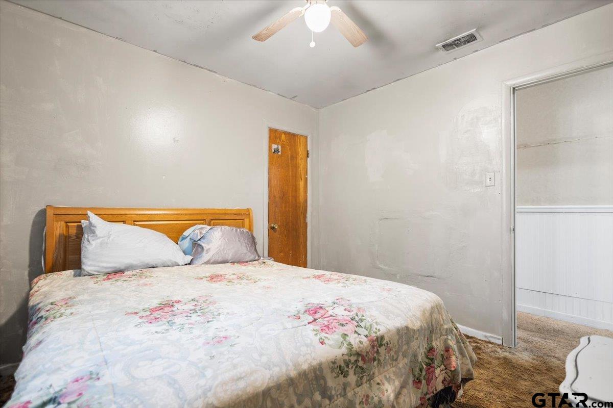 3211 Shady Trail Drive Tyler, TX 75702 - Photo 18 of 30 a bedroom with a bed and a potted plant