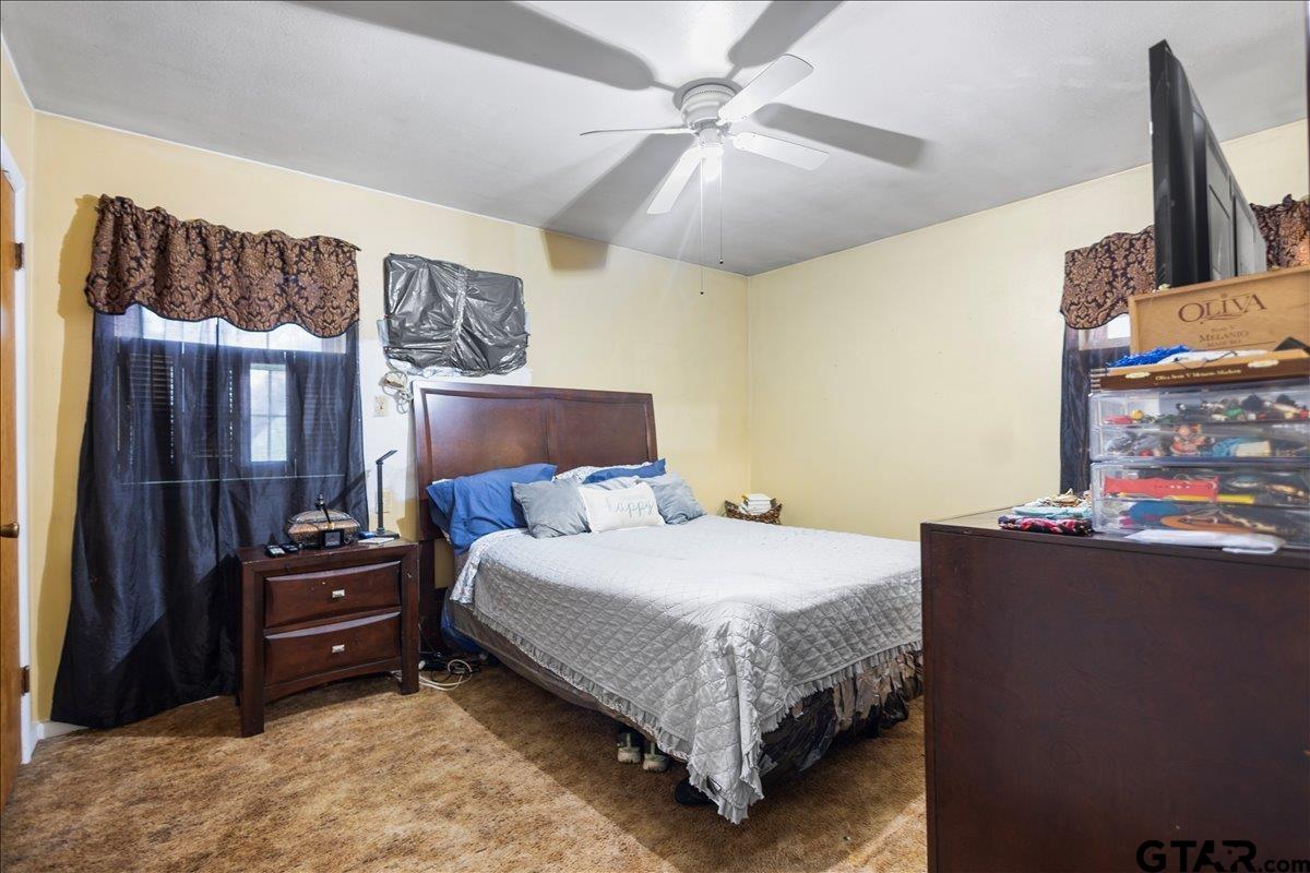 3211 Shady Trail Drive Tyler, TX 75702 - Photo 22 of 30 a bedroom with a bed and a chandelier