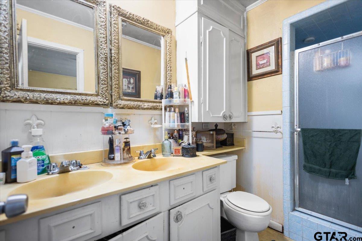 3211 Shady Trail Drive Tyler, TX 75702 - Photo 26 of 30 a bathroom with a sink a toilet and a mirror