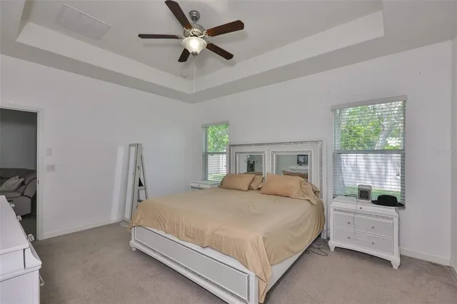 a bedroom with a bed a window and a chandelier