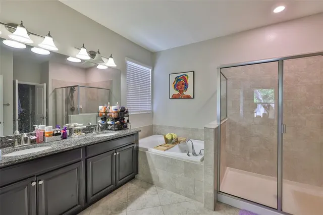 a bathroom with a tub a sink and mirror