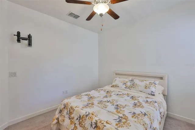 a bedroom with a bed and a ceiling fan