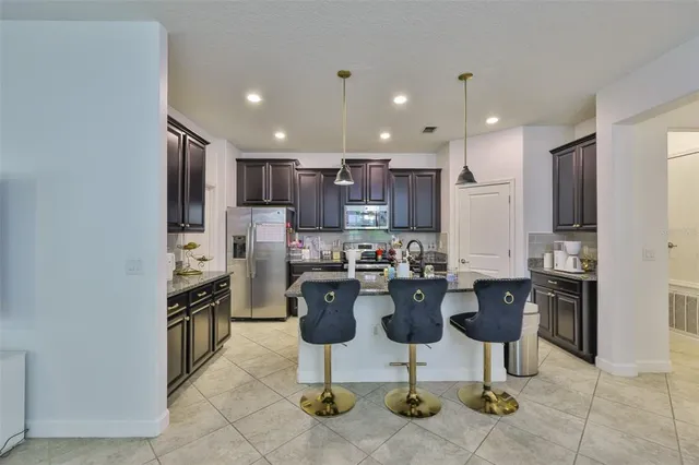 a kitchen with stainless steel appliances kitchen island granite countertop a refrigerator and a stove top oven