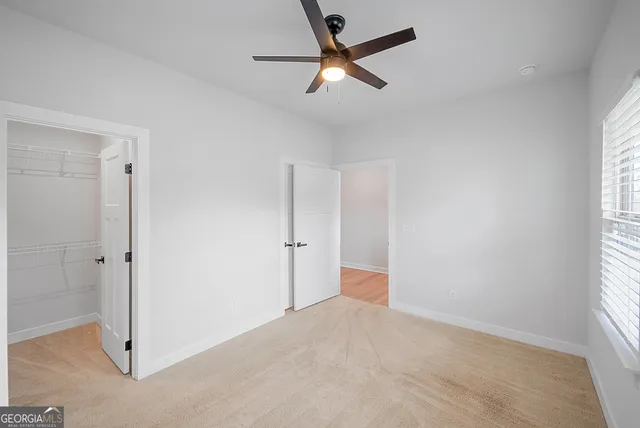 a view of a livingroom with a ceiling fan and window