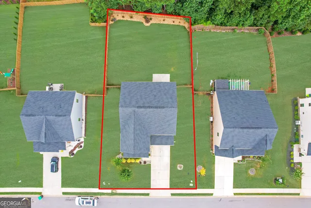 an aerial view of a house with a garden and lake view