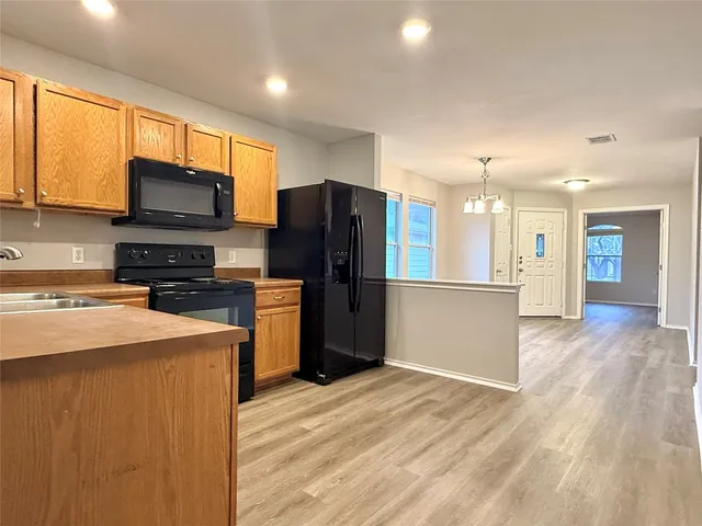 a kitchen with stainless steel appliances granite countertop a refrigerator stove top oven a sink and dishwasher