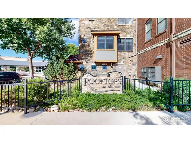 a picture of a street with potted plants and big trees