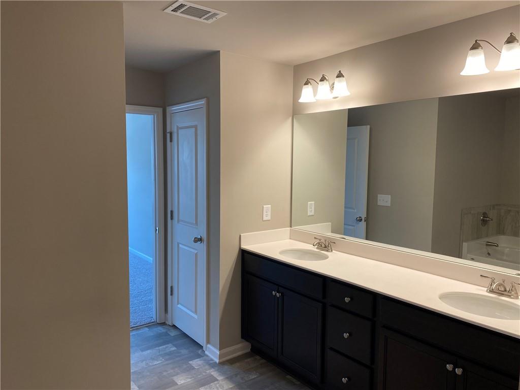 5282 Fox Den Road Oakwood, GA 30566 - Photo 7 of 14 a bathroom with a double vanity sink and a mirror
