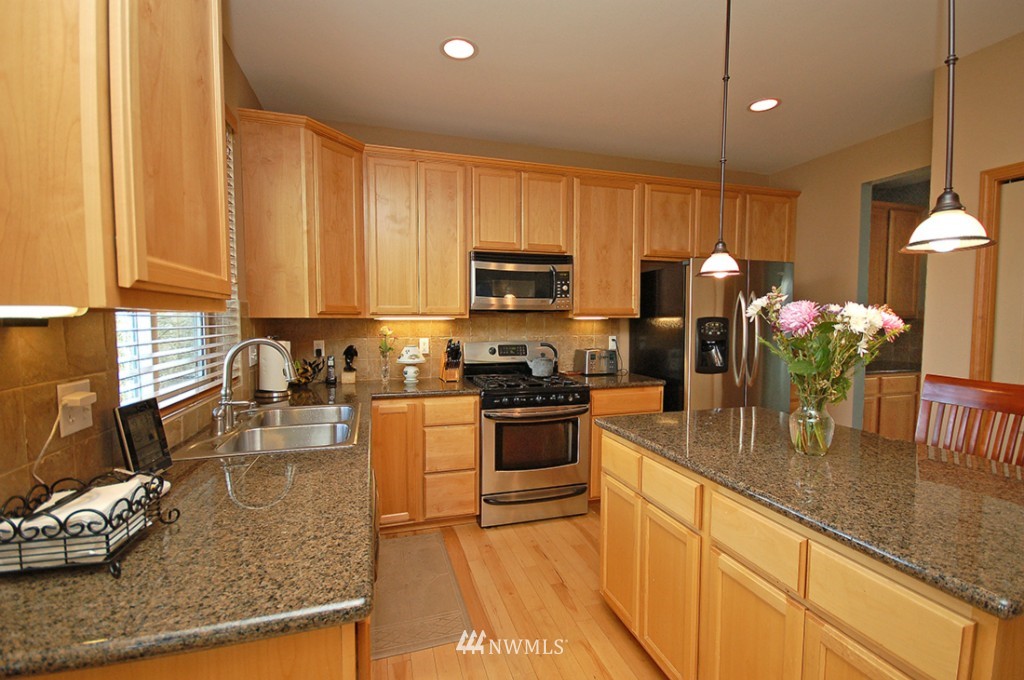 21107 1st Avenue West Bothell, WA 98021 - Photo 10 of 20 a kitchen with kitchen island granite countertop a sink counter top space appliances and cabinets