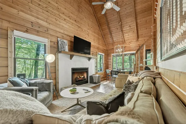 a living room with furniture a fireplace and a flat screen tv