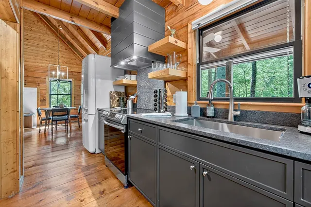 a kitchen with stainless steel appliances granite countertop sink stove and wooden cabinets