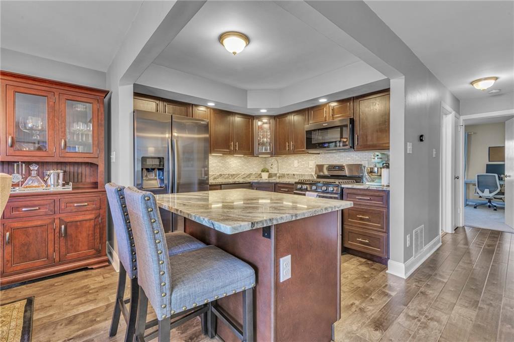 610 Maple Lane, Unit 1 Sewickley, PA 15143 - Photo 4 of 31 a kitchen with granite countertop a stove a sink a dining table and chairs