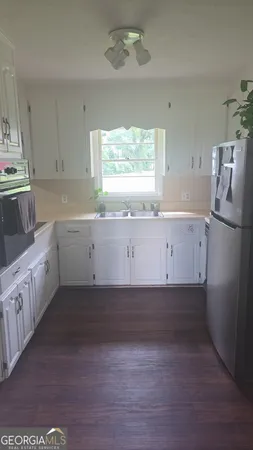 a kitchen with granite countertop white cabinets and white appliances