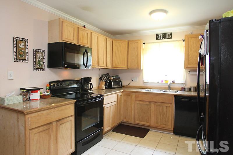 4706 Revere Road Durham, NC 27713 - Photo 5 of 13 a kitchen with a sink stove and refrigerator