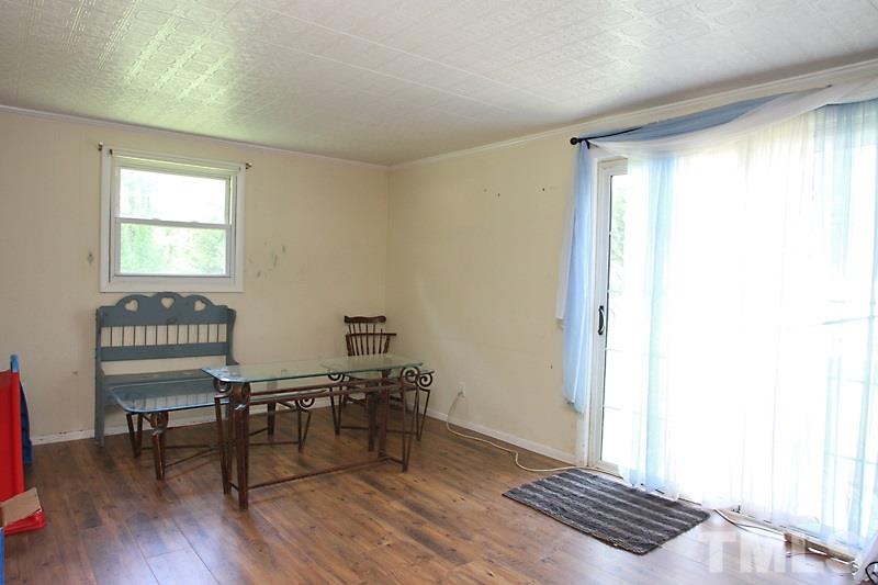 4706 Revere Road Durham, NC 27713 - Photo 6 of 13 a view of a room with wooden floor furniture and windows