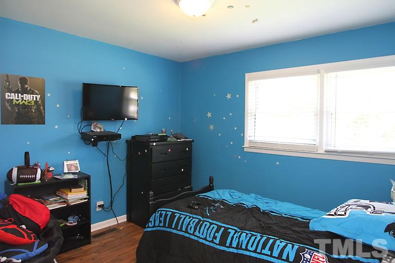 4706 Revere Road Durham, NC 27713 - Photo 8 of 13 a bedroom with a bed and flat screen tv