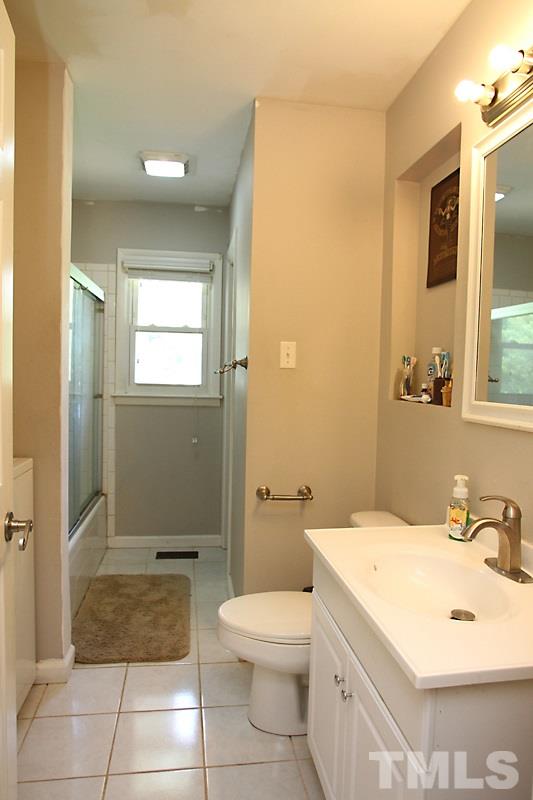 4706 Revere Road Durham, NC 27713 - Photo 9 of 13 a bathroom with a sink a toilet and shower