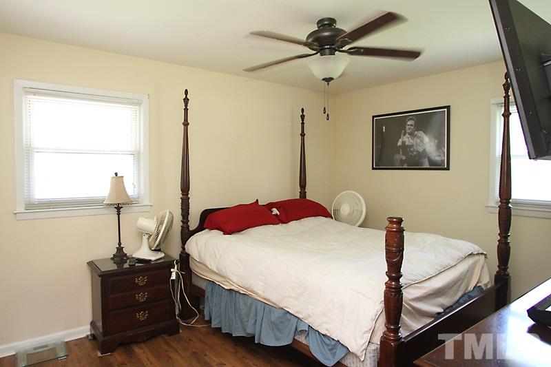 4706 Revere Road Durham, NC 27713 - Photo 10 of 13 a bedroom with a bed and wooden floor