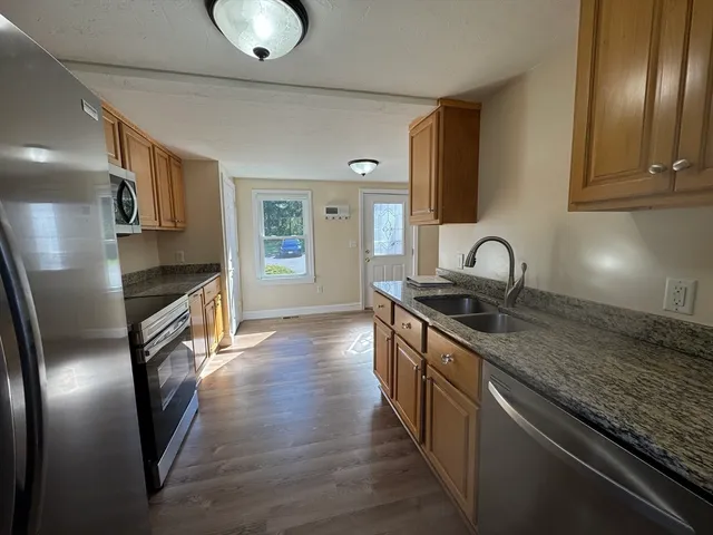 a kitchen with stainless steel appliances granite countertop a sink stove and refrigerator