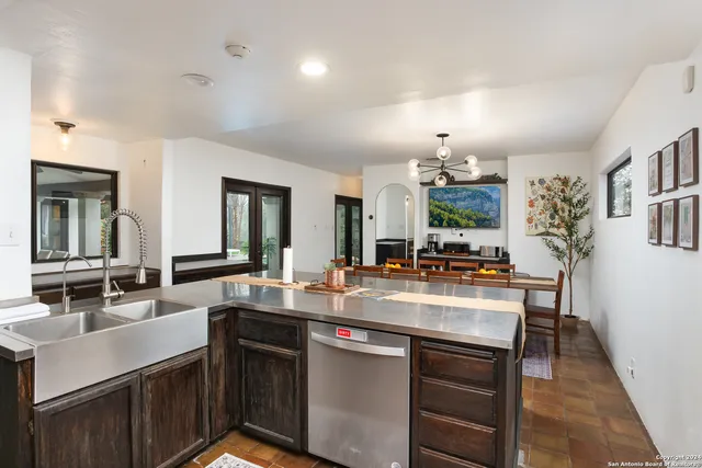 a kitchen with kitchen island granite countertop a sink stove and cabinets