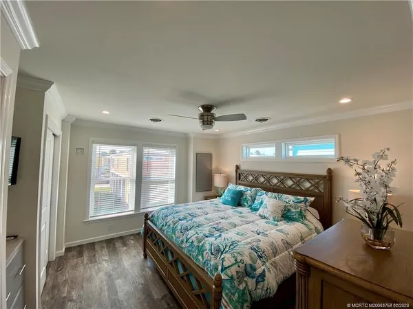 a bedroom with a large bed a chandelier and dresser