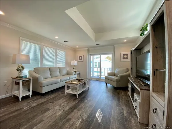 a living room with furniture flat screen tv and wooden floor
