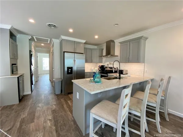 a kitchen with a dining table chairs refrigerator and cabinets
