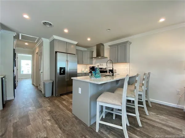 a kitchen with stainless steel appliances granite countertop a refrigerator and a stove top oven