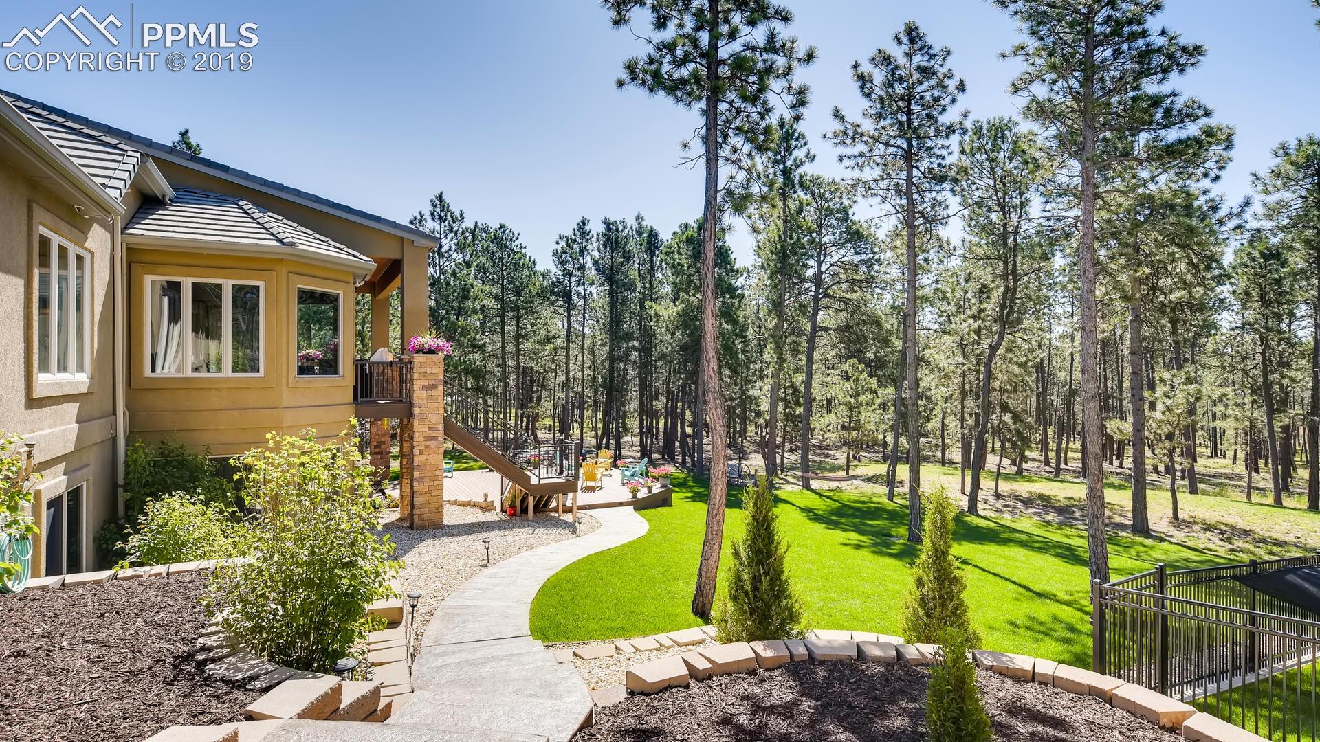 4061 High Forest Road Colorado Springs, CO 80908 - Photo 31 of 40 Professional landscaping includes walkways around perimeter of home.