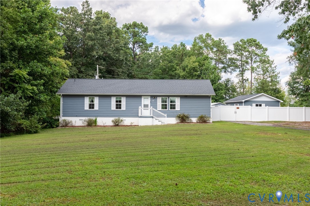 173 Antioch Road Warfield, VA 23889 - Photo 13 of 26 a front view of a house with a garden and trees